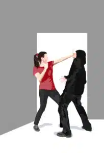 Woman defending herself against a hooded man in dark clothing created for US Martial Arts Academy, Ltd., Cockeysville, Md. 21030